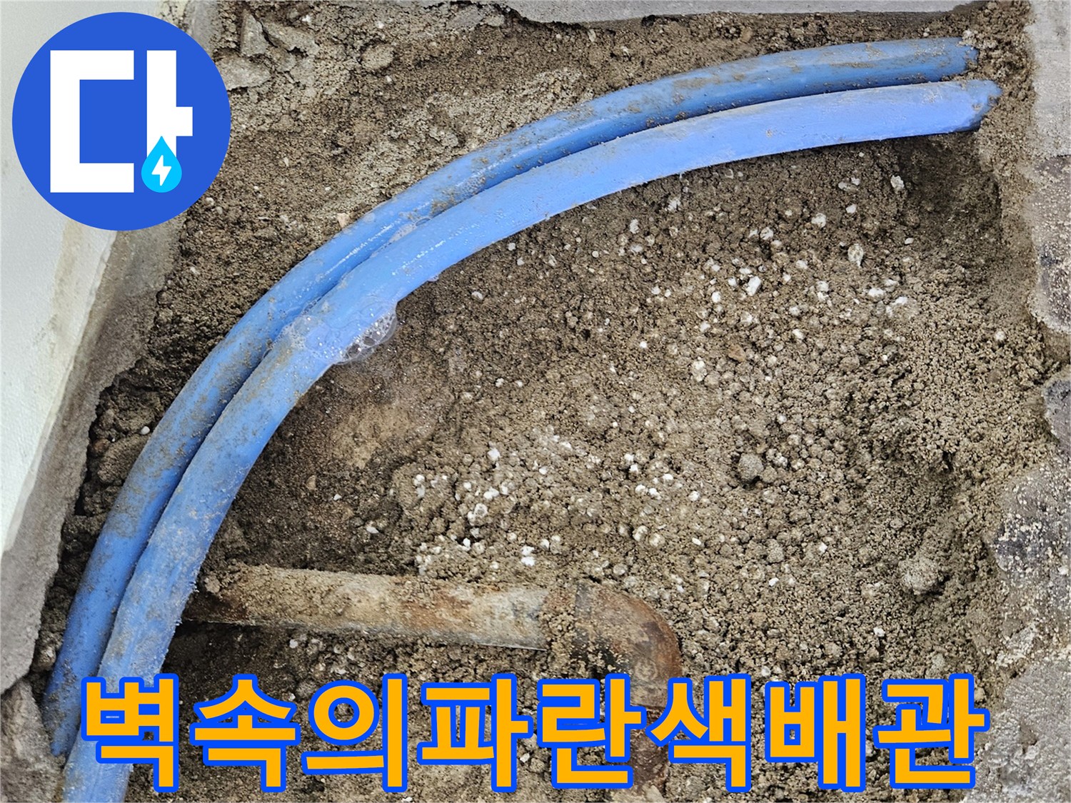굴착된-콘크리트-사이-노출된-파란색-배관