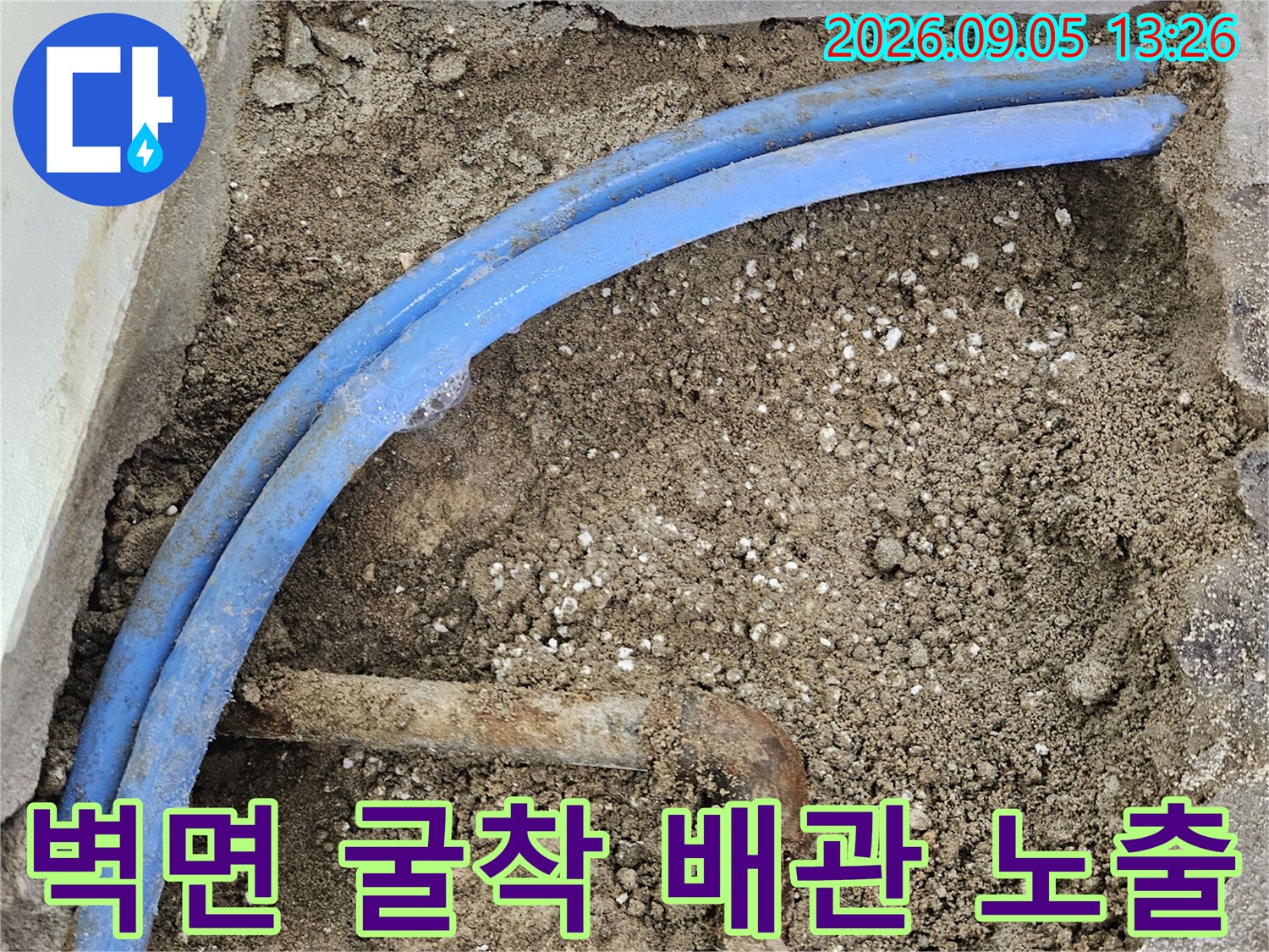 벽면을 파헤쳐 드러낸 푸른색 수도 배관과 부식된 연결관