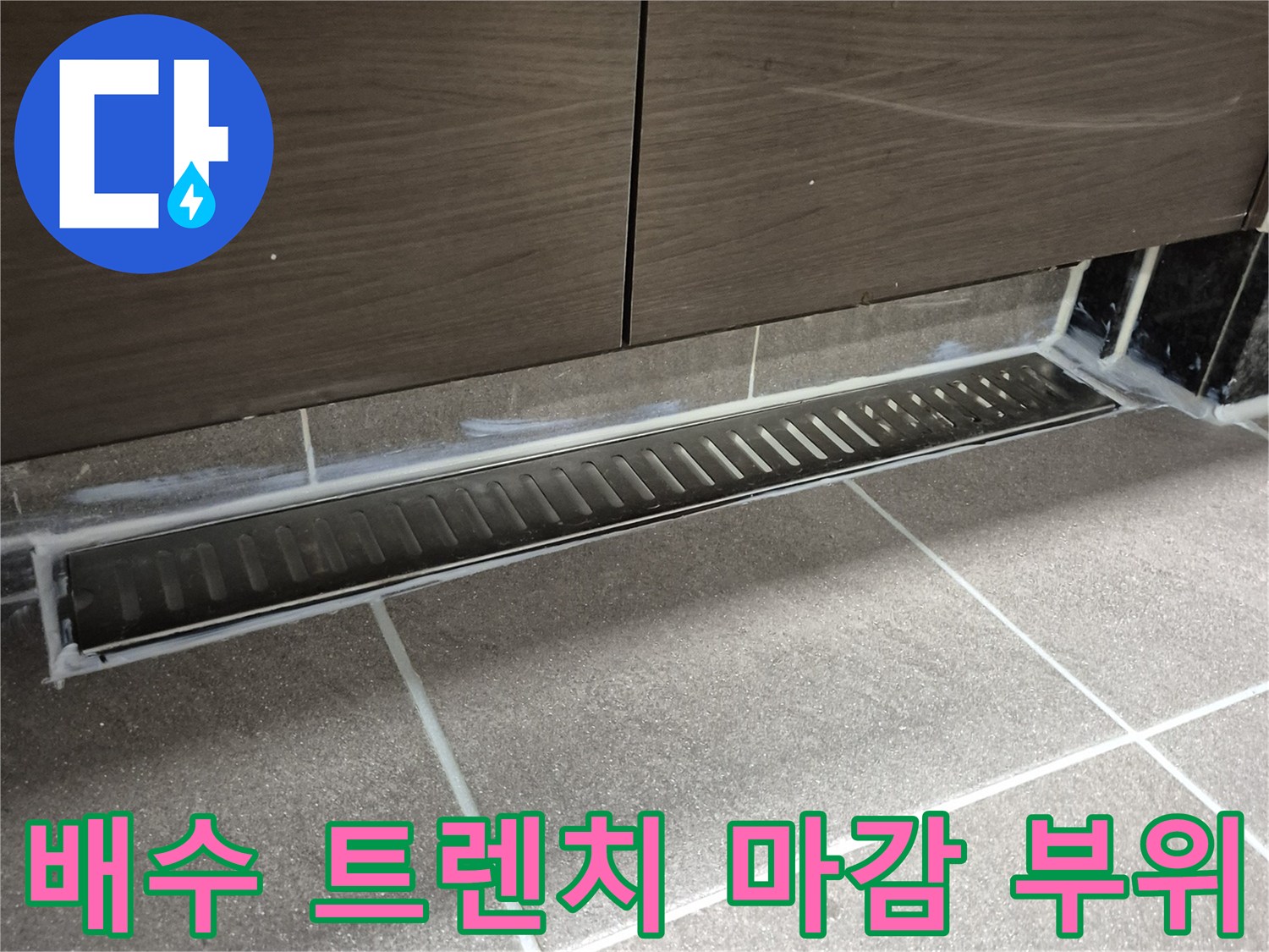 화장실 바닥-길게 설치된 배수 트렌치와 타일 접합부