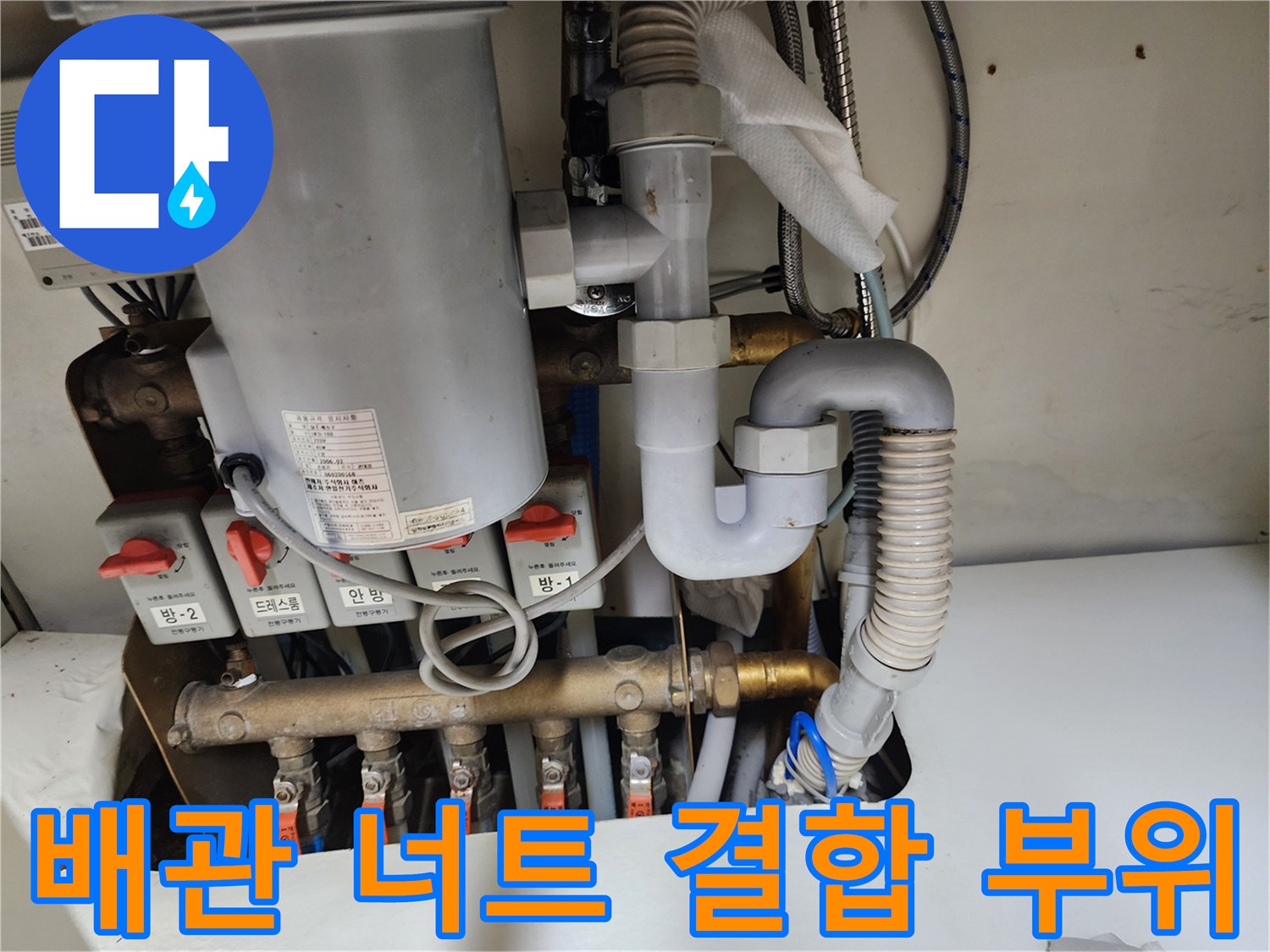 싱크대 하부의 복잡한 배관과 밸브 연결 구조물