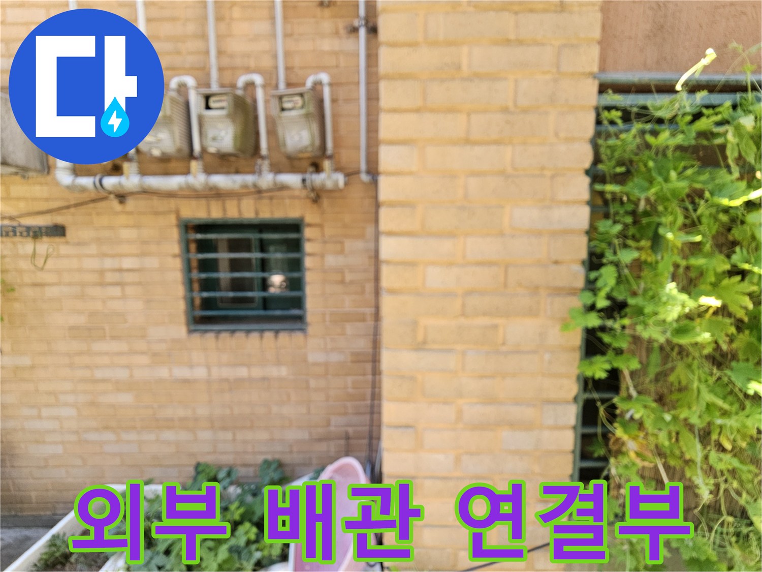 빌라 외벽에 설치된 4개의 수도 계량기와 연결된 외부 배관 모습입니다.
