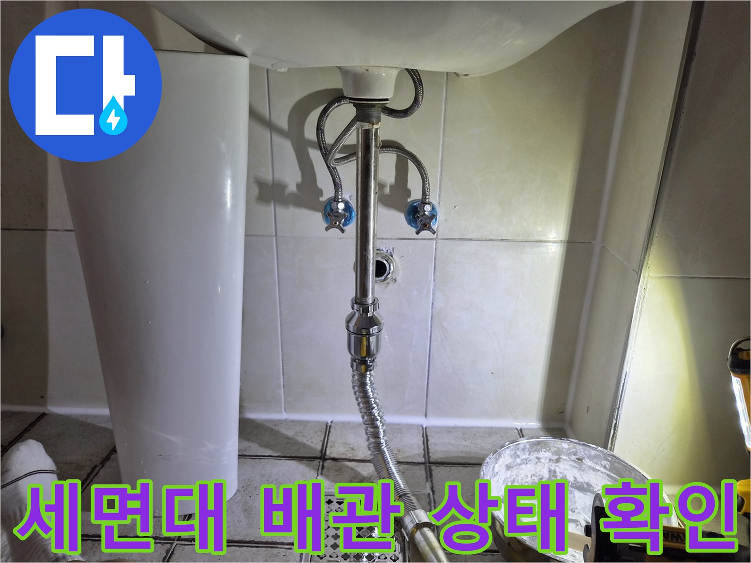 세면대 아래쪽 배수 호스와 벽면 타일 연결 부위 모습