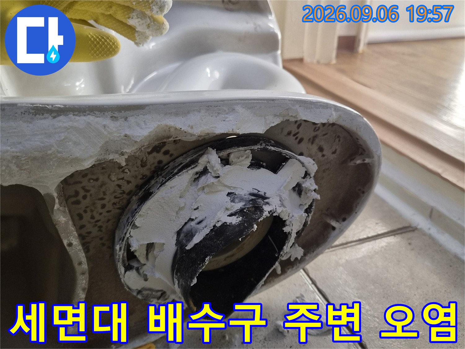세면대 하단 배수 부위의 낡은 마감재와 이물질이 섞인 상태입니다.