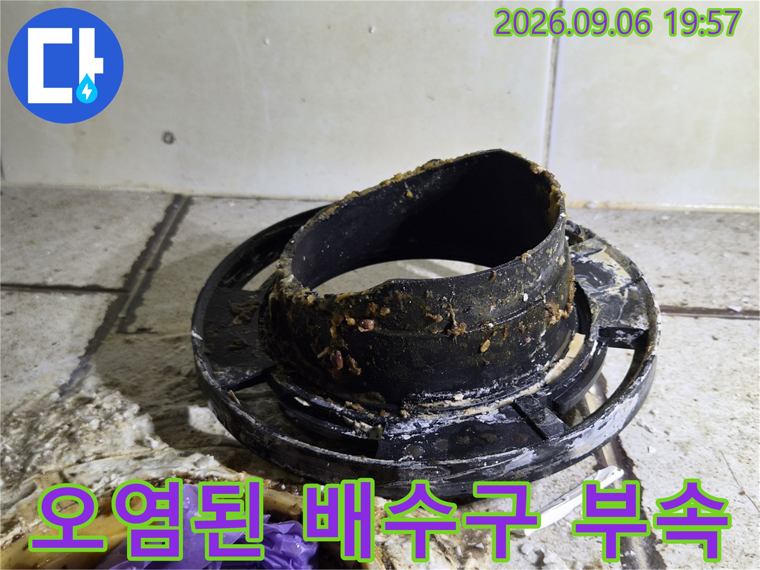 찌꺼기가 묻어있는 검은색 오수관 부품입니다.