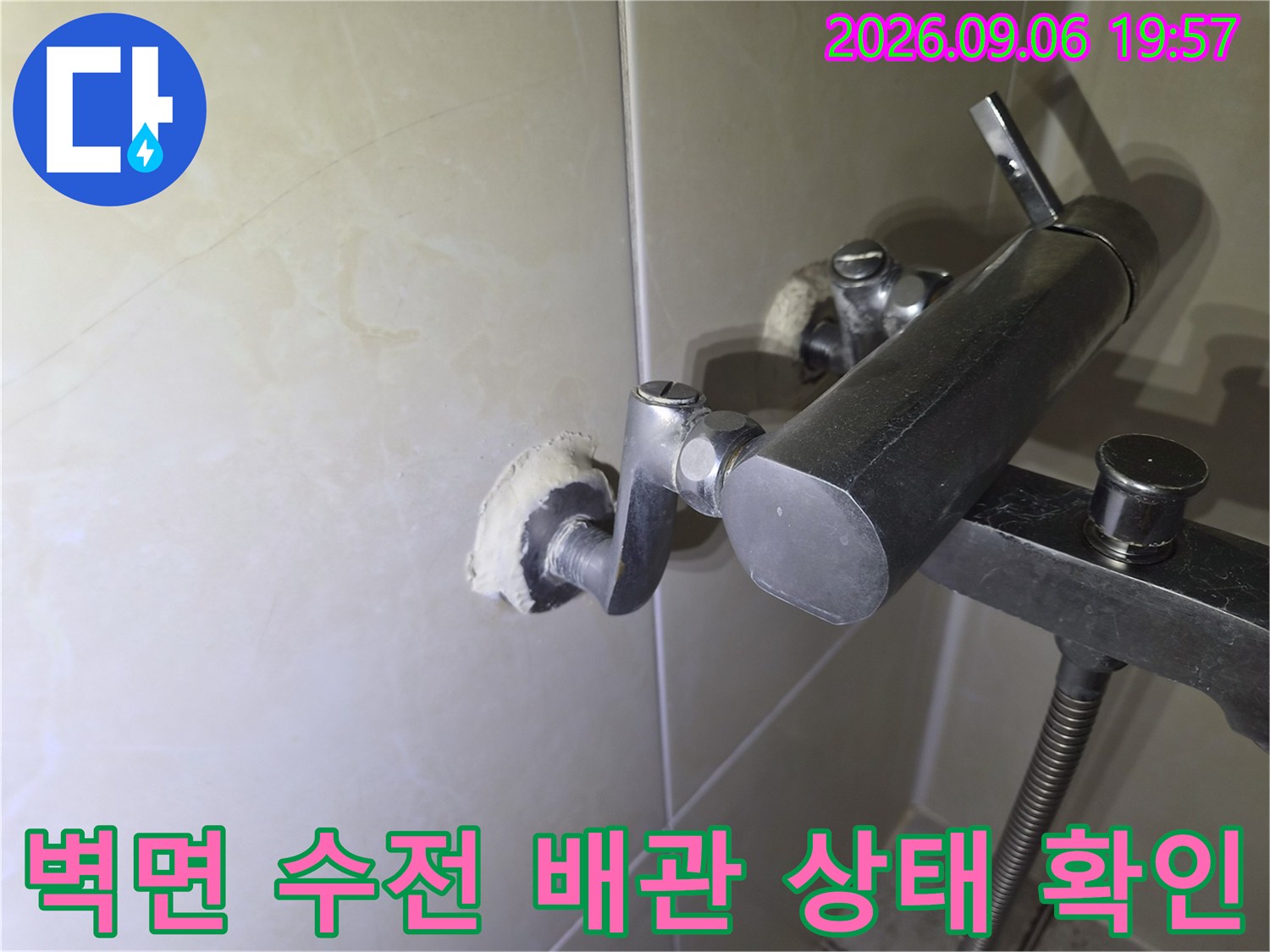 화장실 벽면에 설치된 수도 부속의 연결 지점 근접 촬영