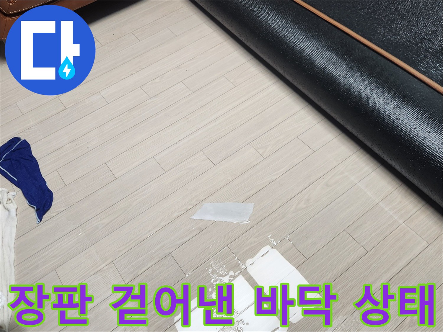 거실 장판을 걷어내고 바닥의 물기를 제거하는 작업 현장입니다.