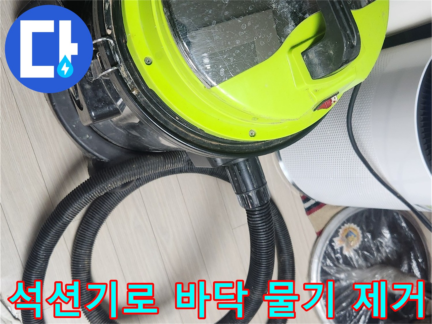 누수 진단을 위해 석션기를 사용하여 바닥의 잔수를 흡입하는 모습