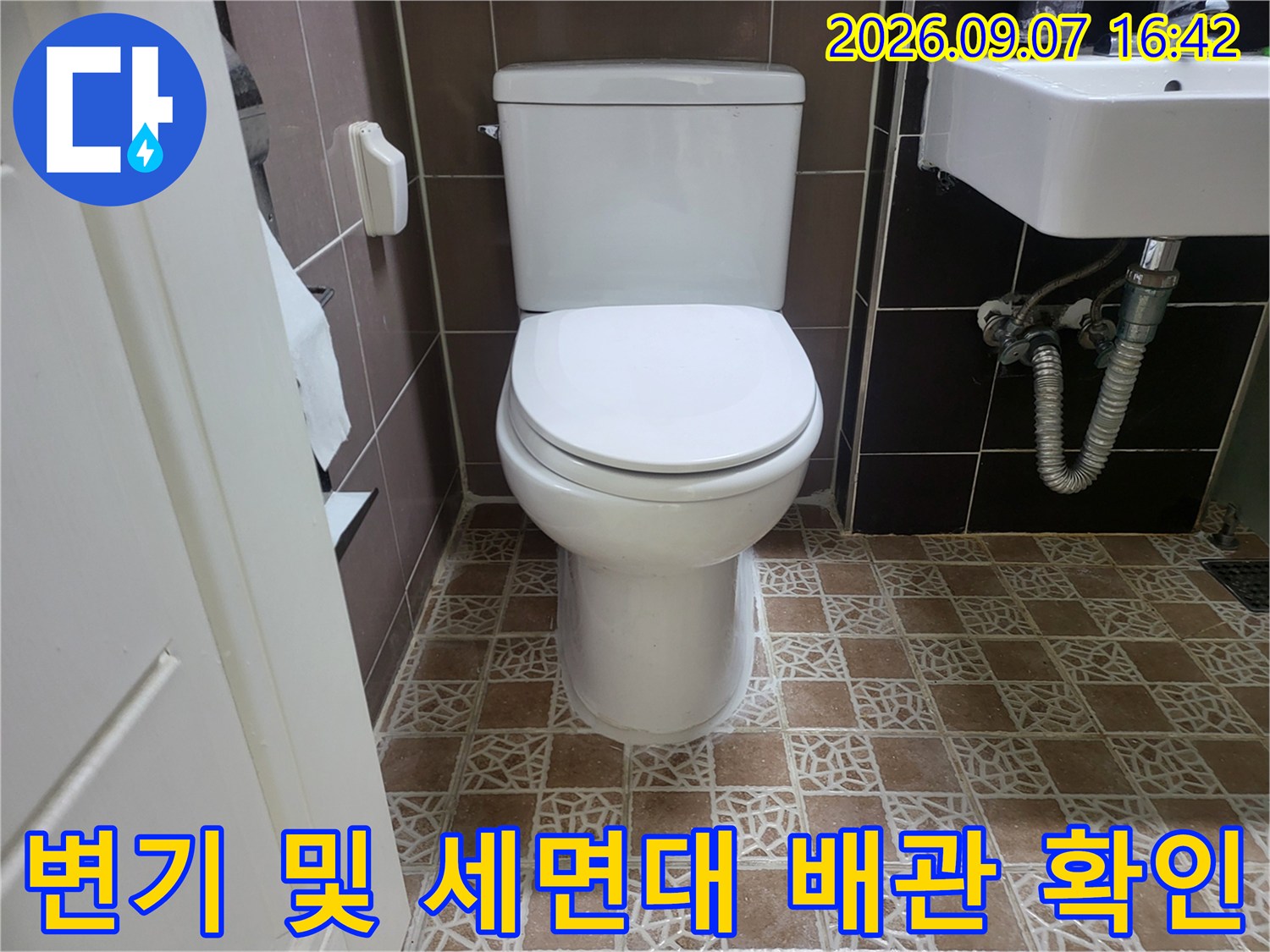욕실 내부의 양변기와 옆에 위치한 세면대 하단 배관 모습입니다.