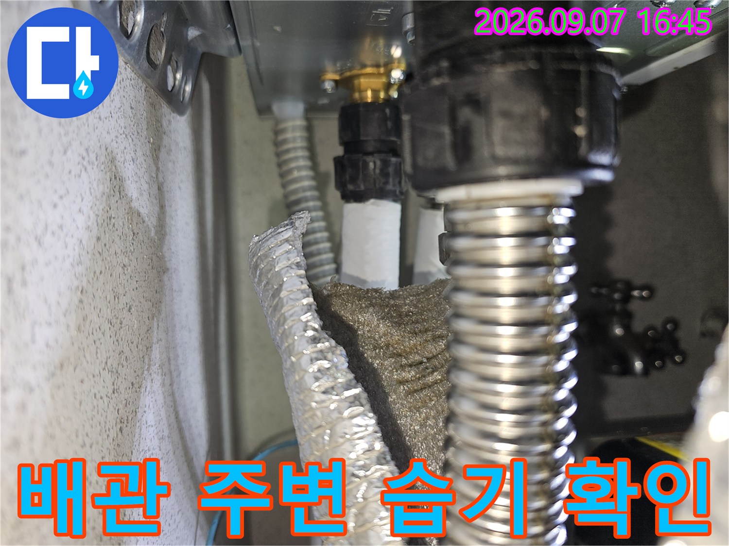 배관 연결 부위의 금속 주름관과 플라스틱 관의 근접 사진