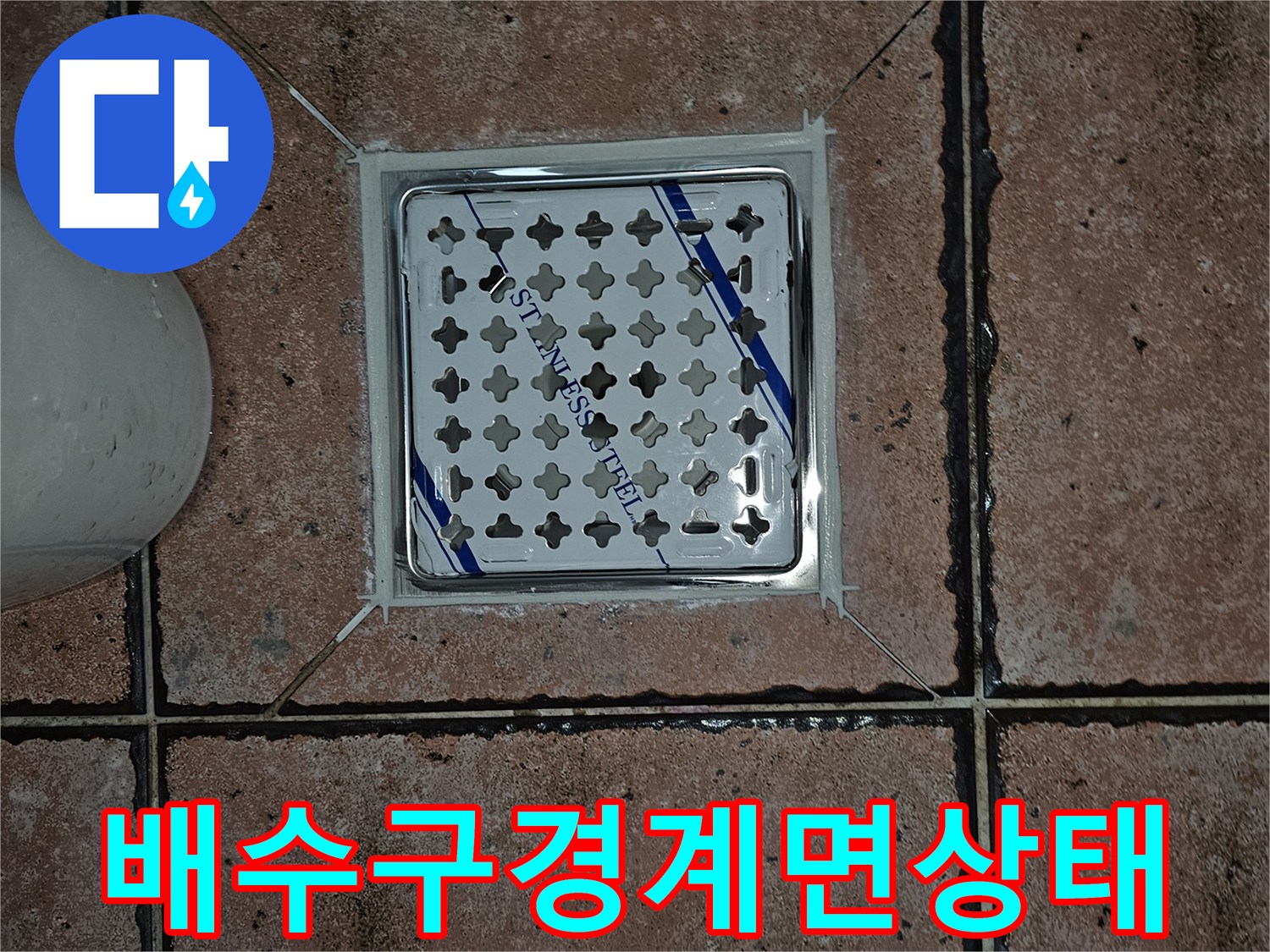 화장실 유가 덮개와 주변 타일의 연결 부위 상세 사진