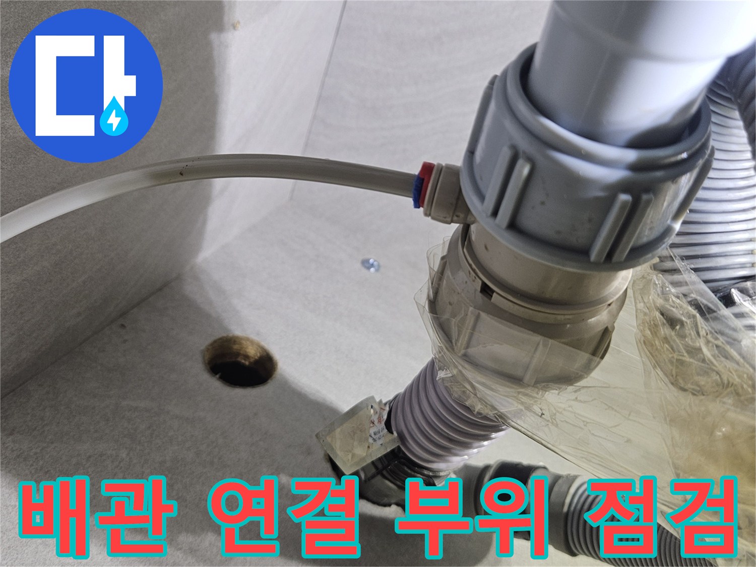 싱크대 하부의 불안정한 배관 및 호스 연결 상태 사진