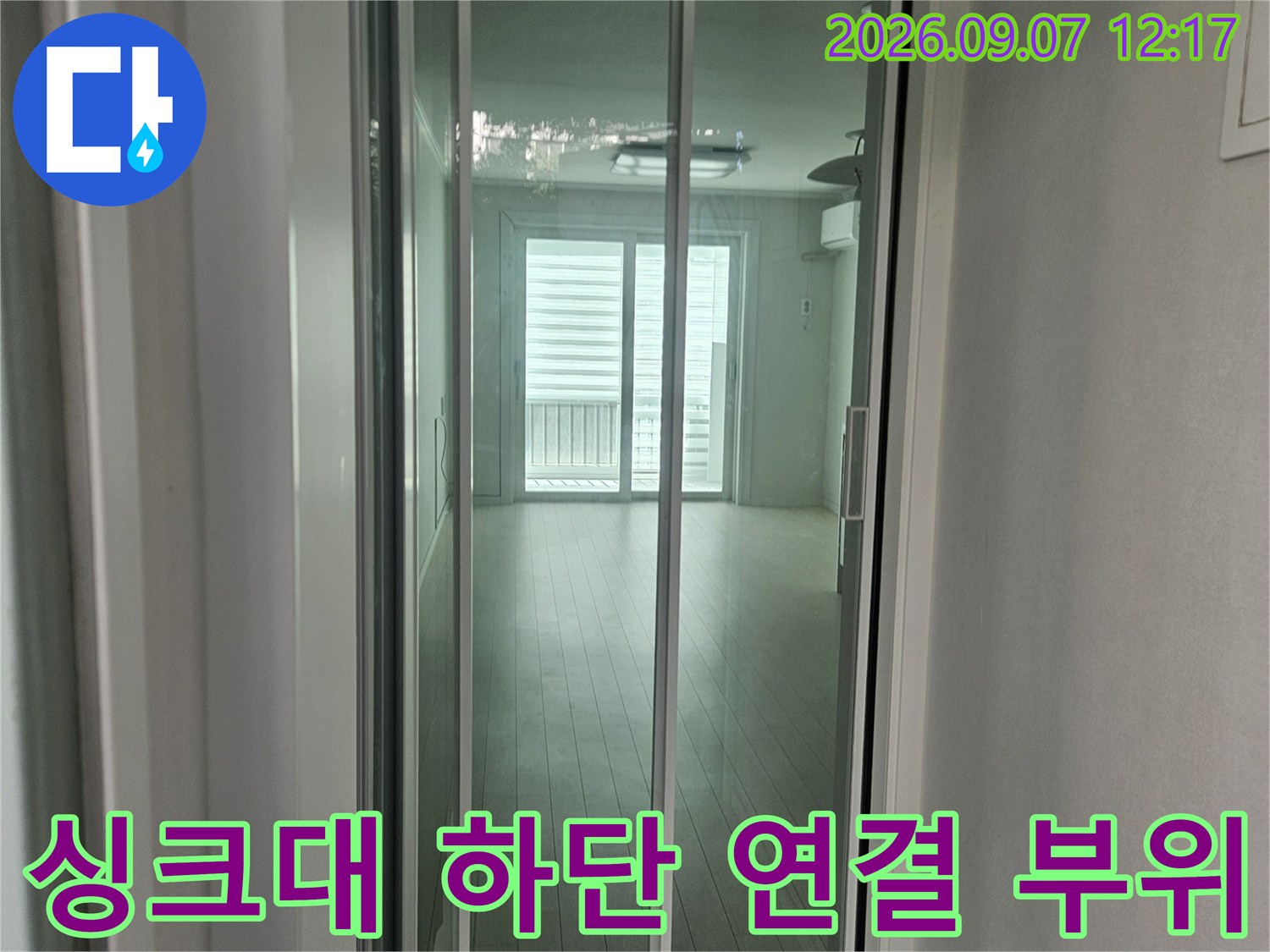 정수기 호스가 훼손되어 물이 새고 있는 싱크대 아래쪽 배관 사진