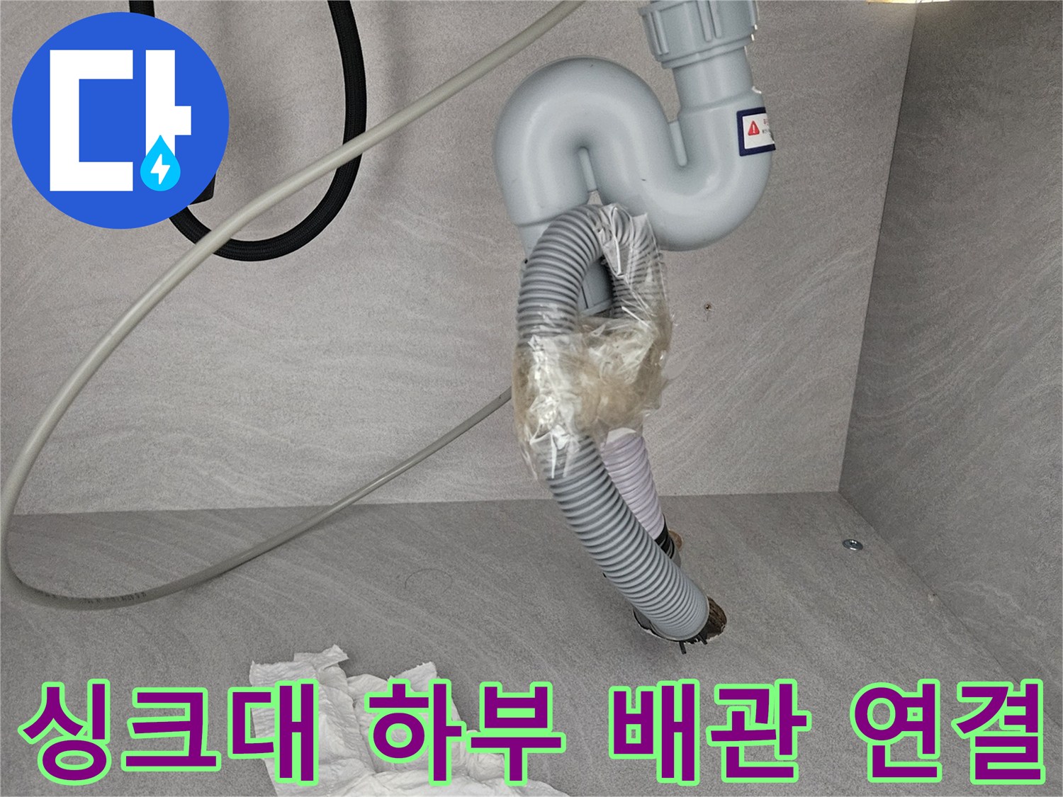테이프로 임시 고정되어 물이 새는 싱크대 배수 호스 부위