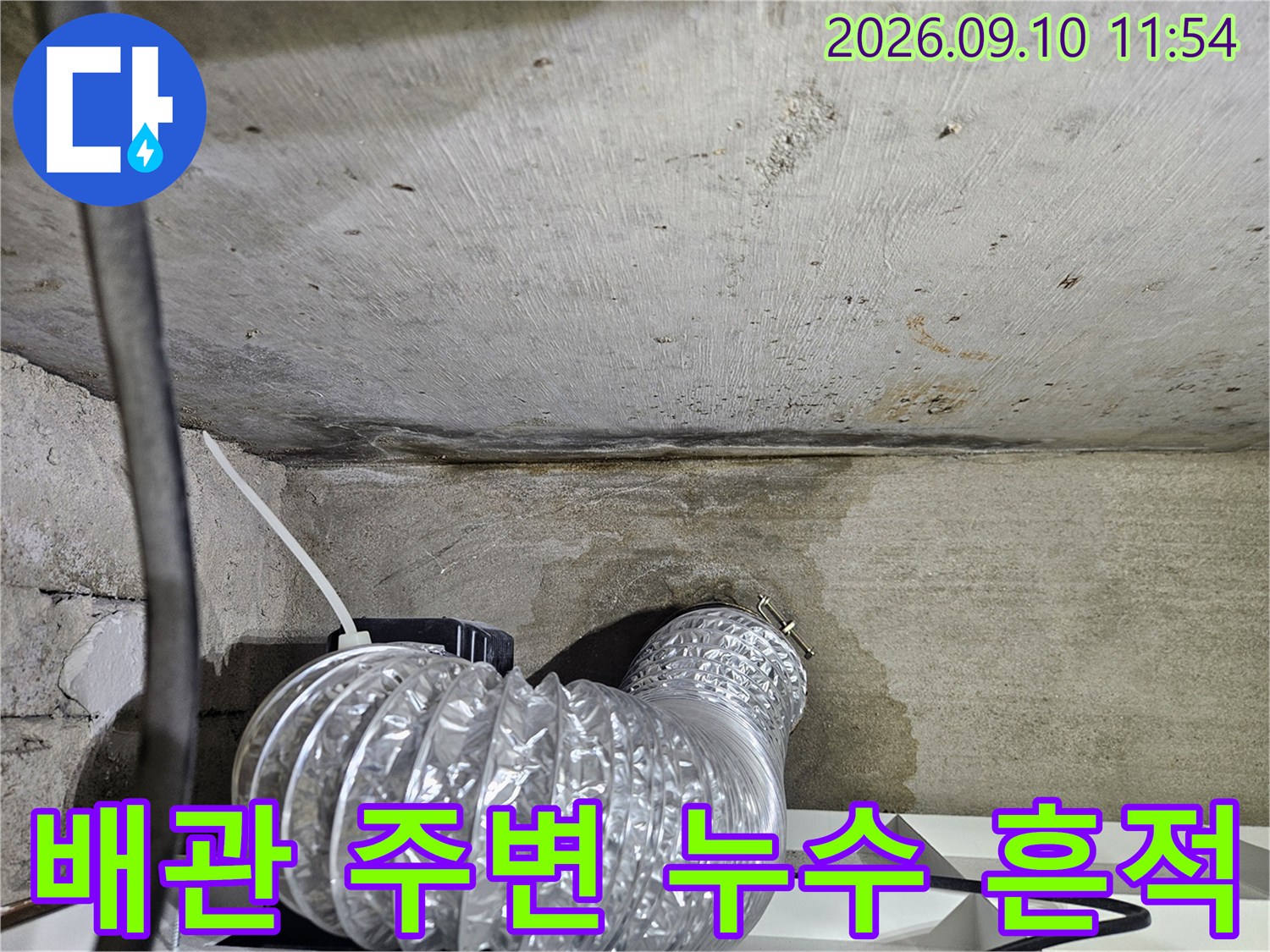 물샘 흔적이 남은 콘크리트 천장과 은색 자재 배관 연결 부위