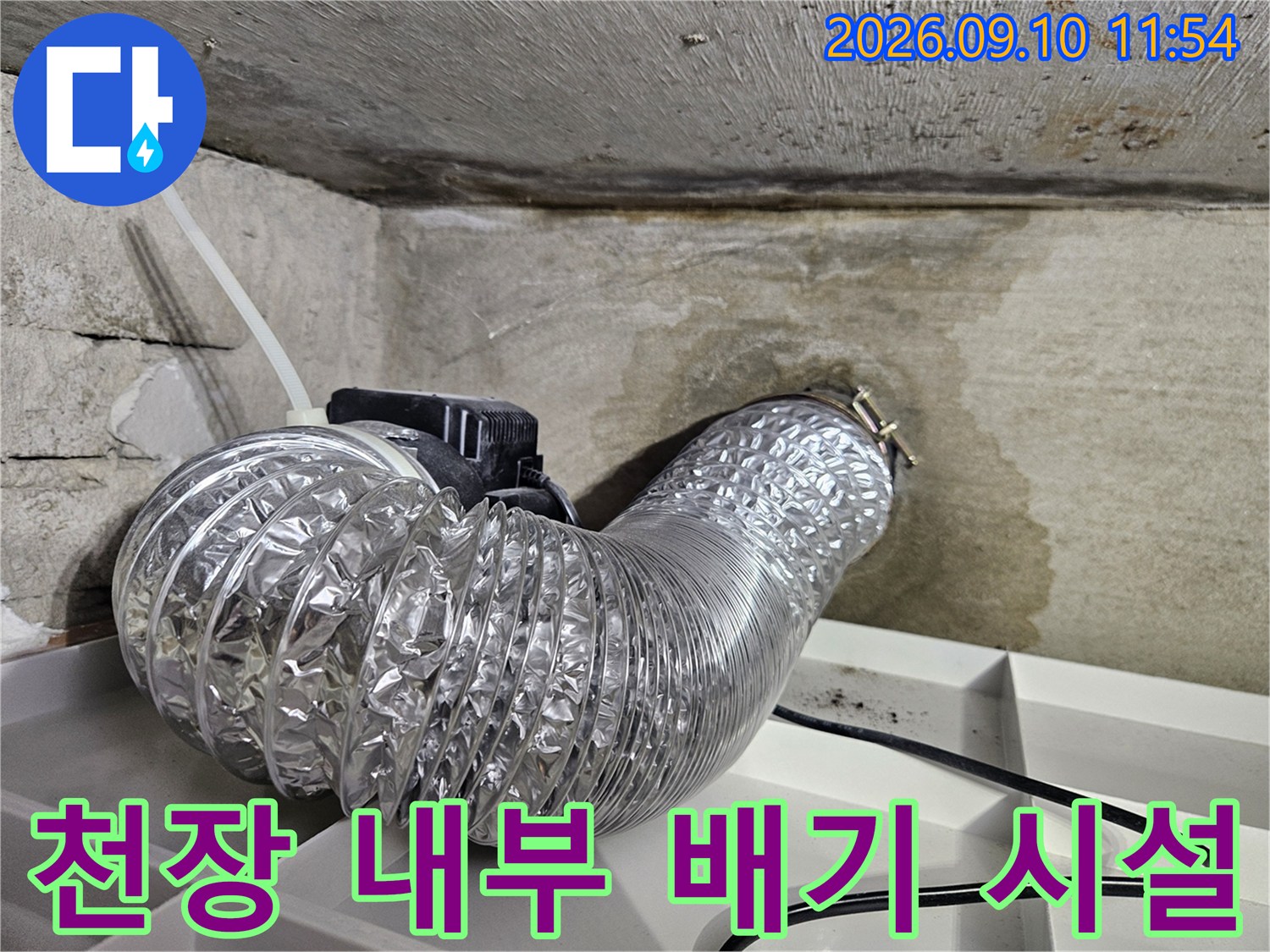 천장 콘크리트 구조물과 연결된 은박 소재의 환기용 덕트 모습