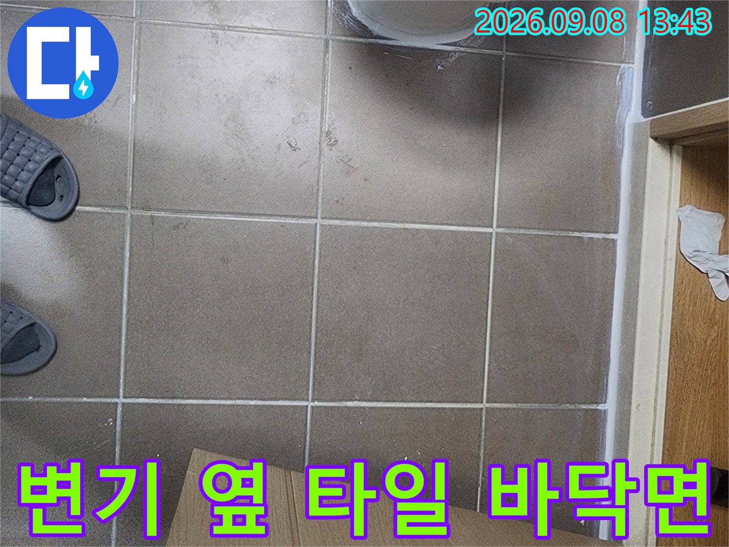 갈색 타일과 변기 하단 부위의 누수 점검 현장 사진입니다.