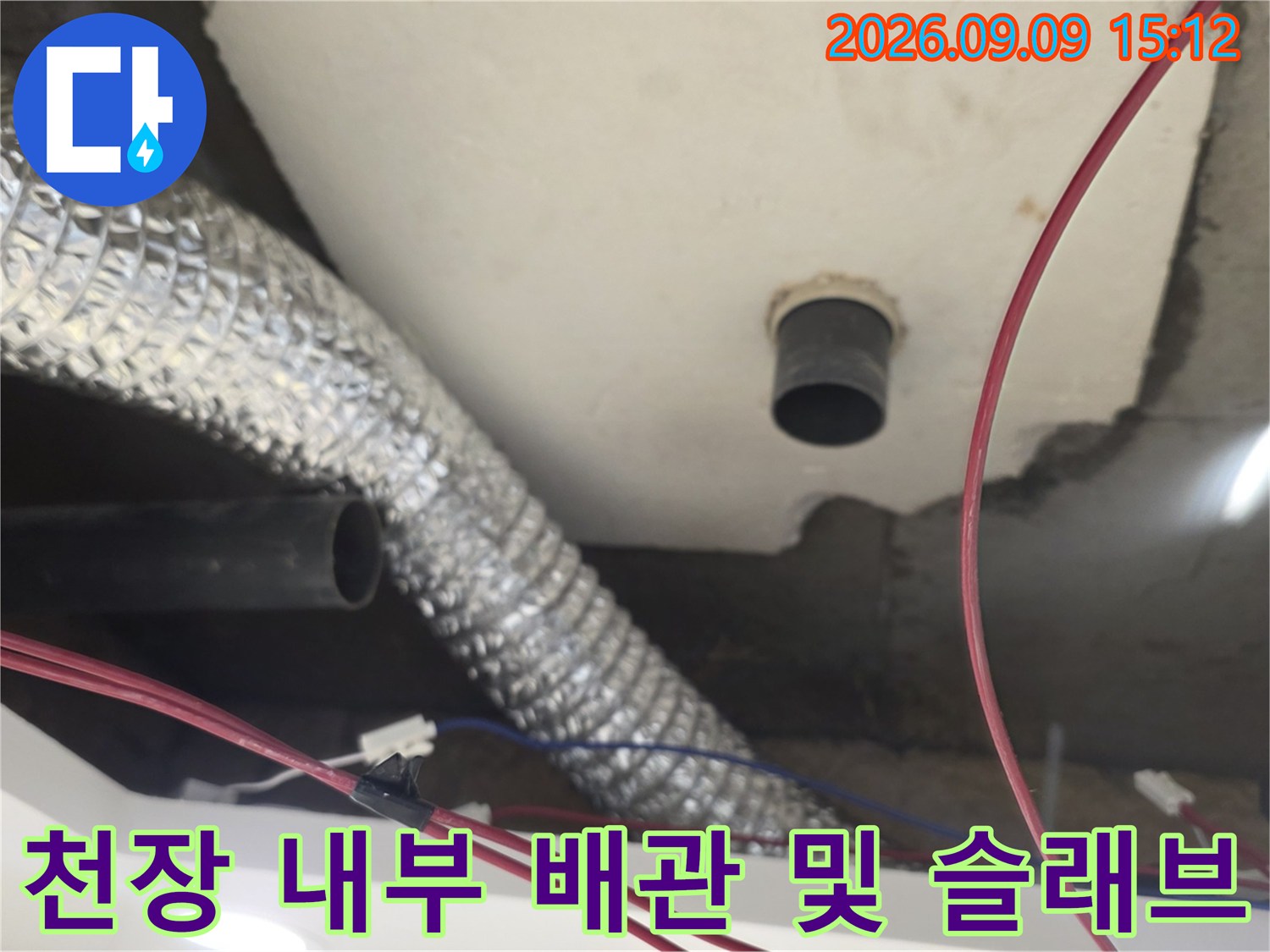 은색 보온 배관과 검은색 배관이 지나가는 천장 구조물 점검 사진