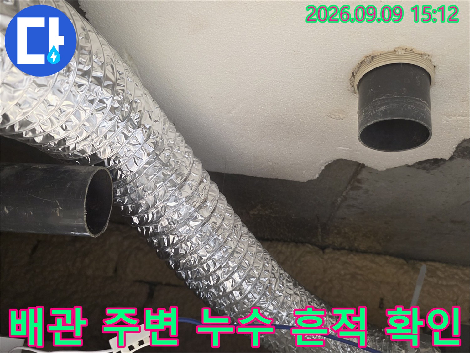 천장 내부 은박 단열 배관과 검은색 하수관 연결 부위 근접 촬영