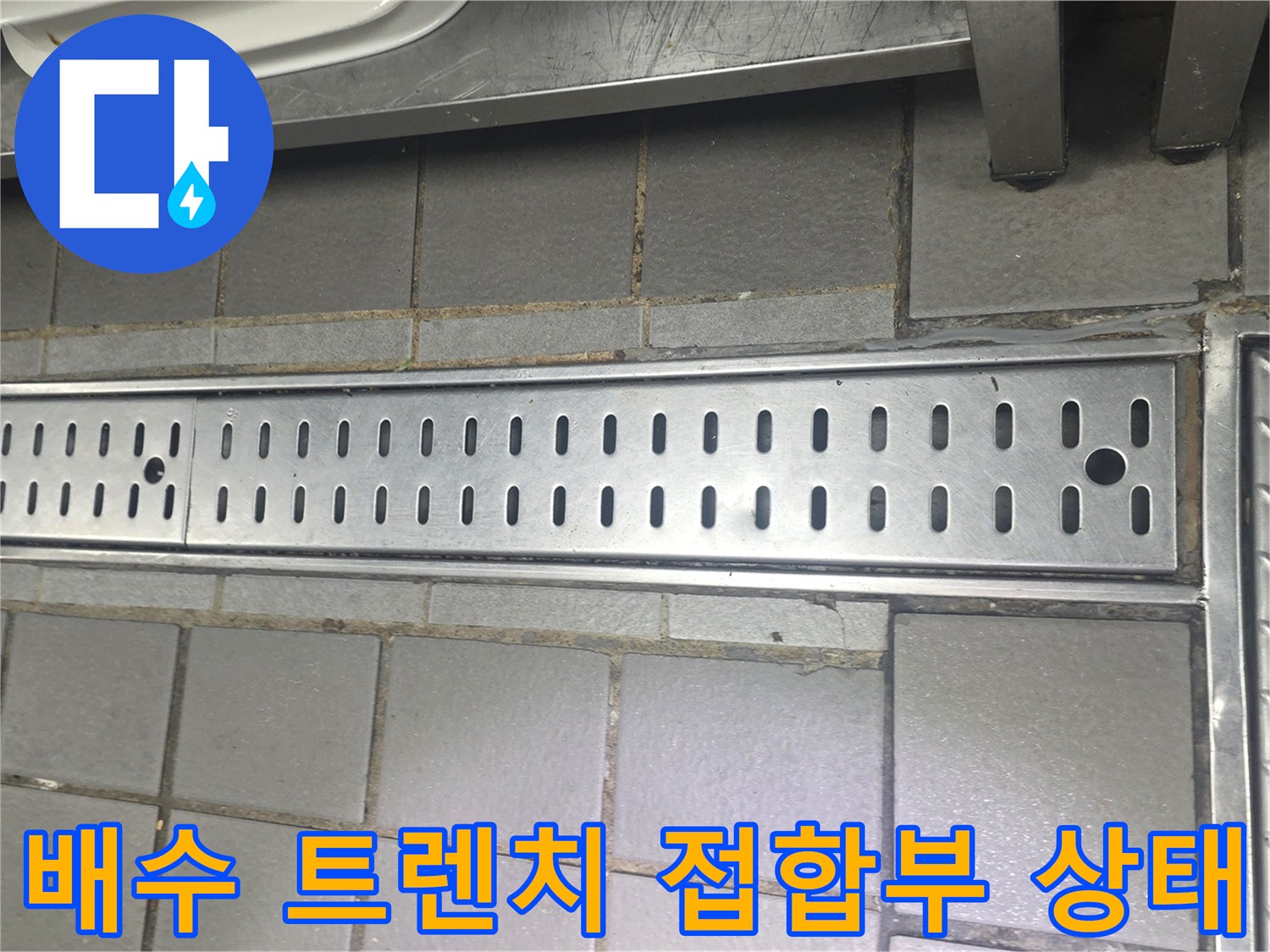 주방 바닥 배수 구조물의 금속 트래치와 타일 마감 모습