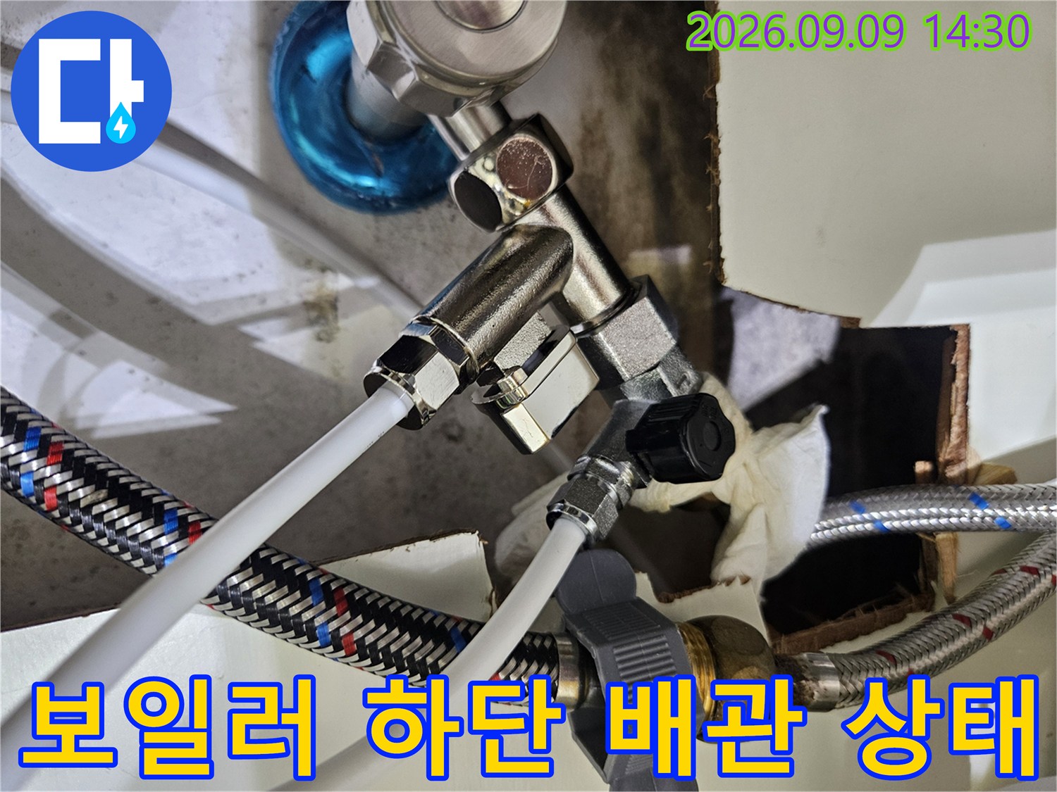 금속 밸브와 은색 메쉬 호스가 연결된 배관 부위 사진