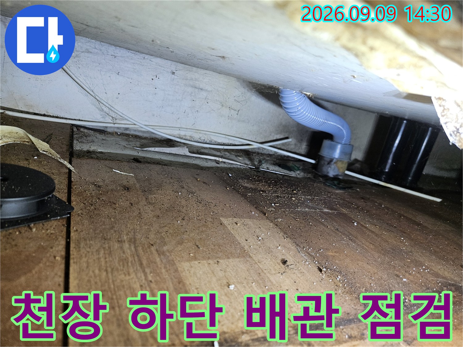파란색 주름 관과 - 천장 마감재의 연결 상태를 촬영한 이미지입니다.