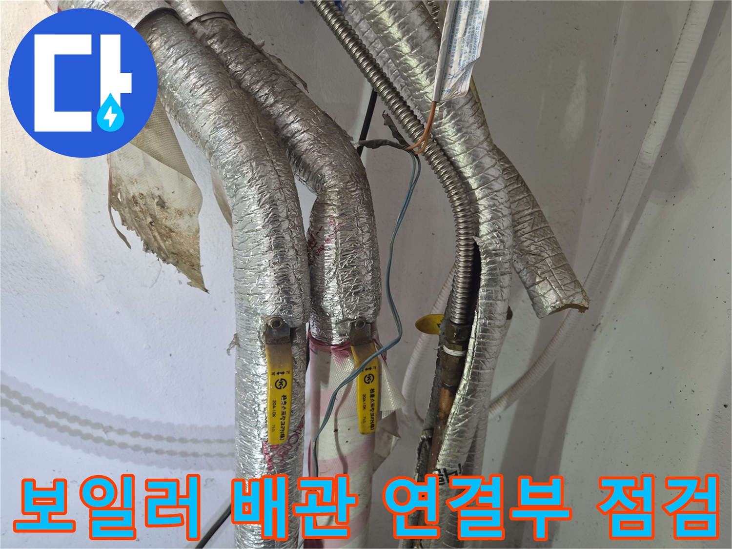 은박 보온재로 감싸진-보일러 주름관과 금속 커넥터 부위의 상태를 확인하는 사진입니다.