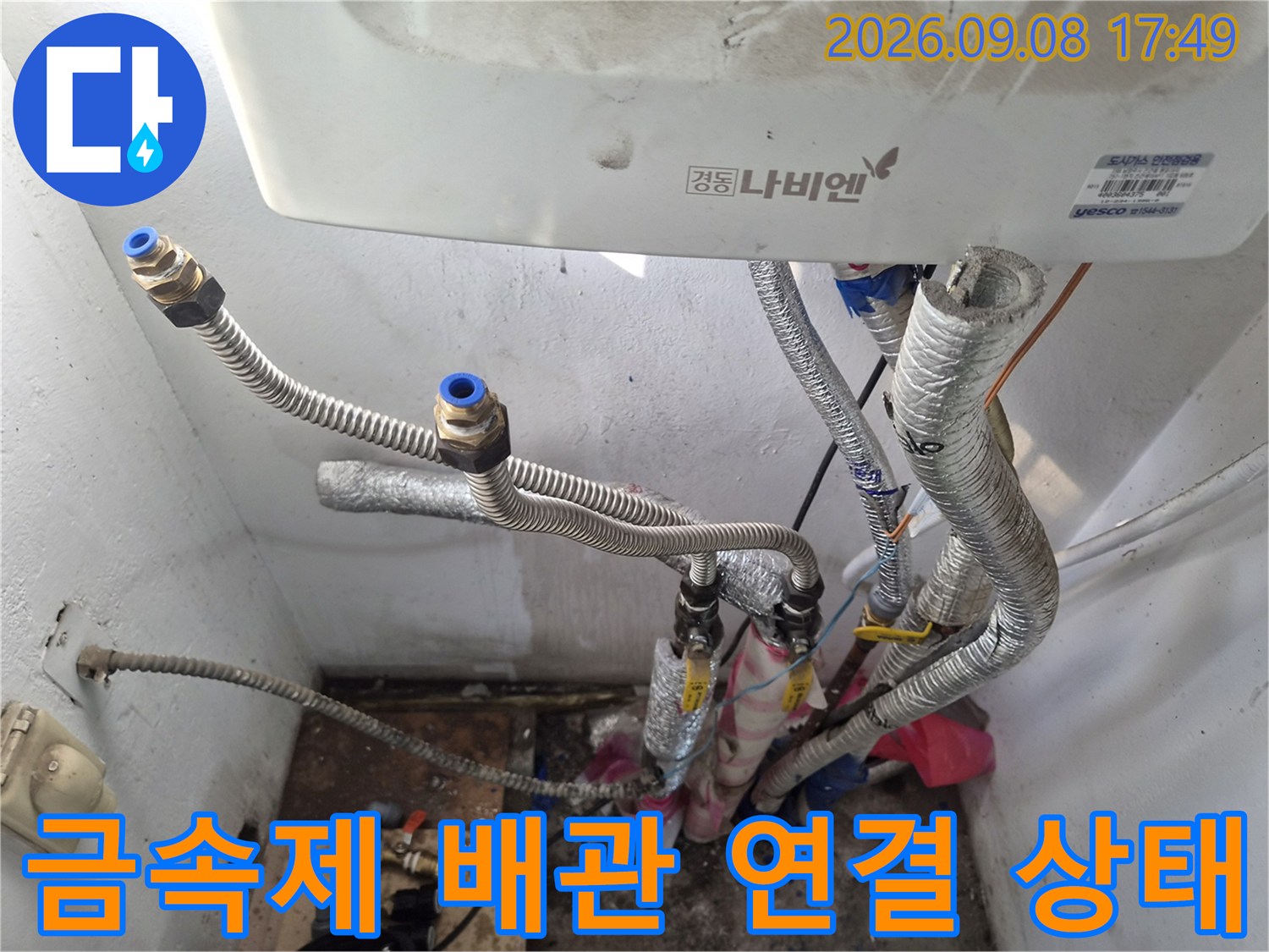 은색 금속 재질로 된 보일러 하부 배관의 상세 모습
