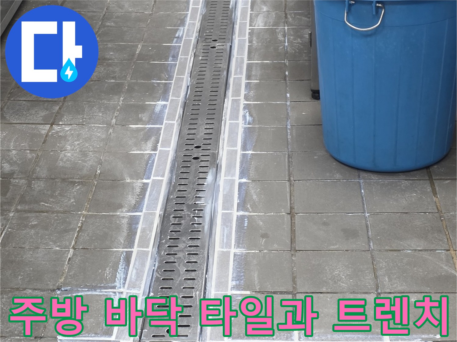 금속 재질의 트렌치 커버와 주변 타일 사이의 틈새를 나타내는 사진입니다.