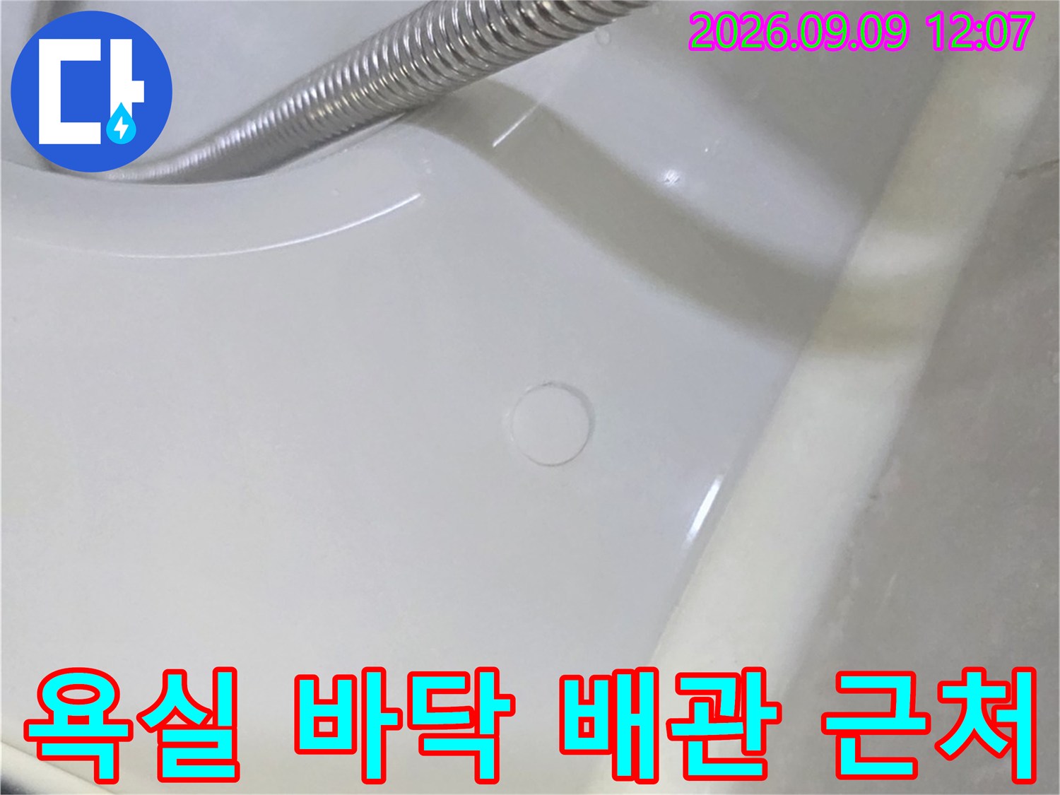 금속 샤워 호스와 흰색 세면대 경계면 촬영