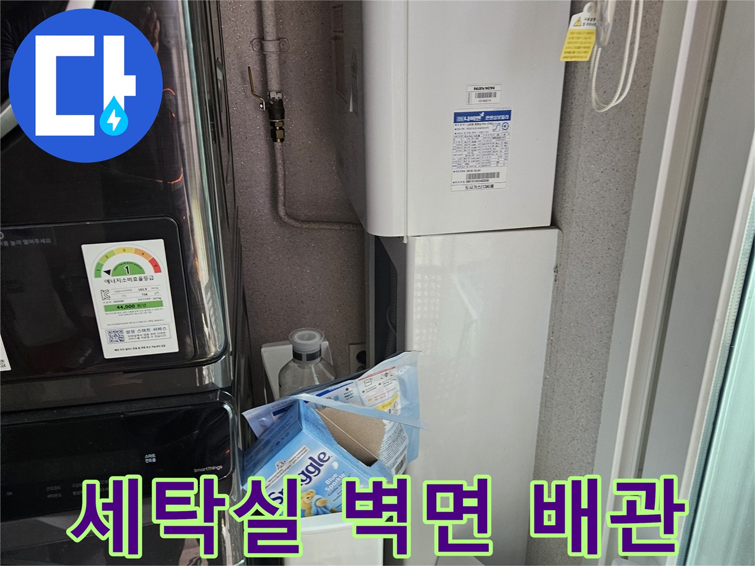 다용도실 벽면에 설치된 배관과 가전제품 하단부