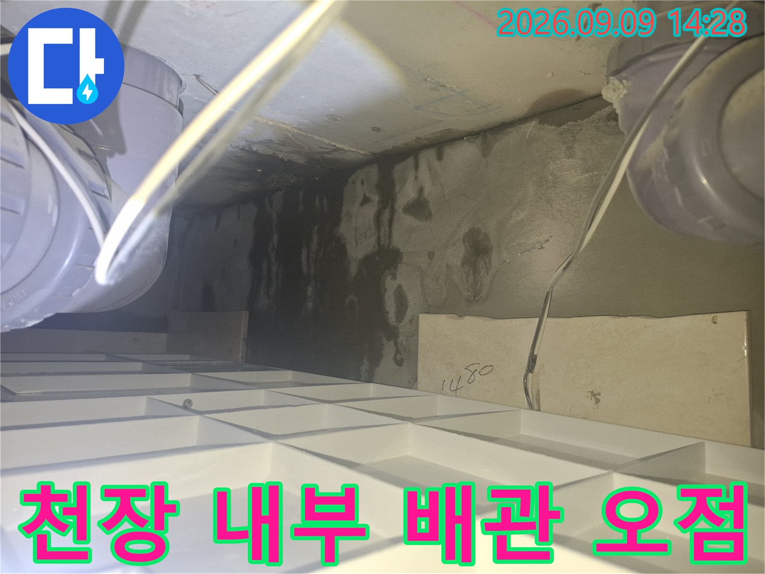 천장 배관 주변의 어두운 누수 흔적과 오염된 마감재