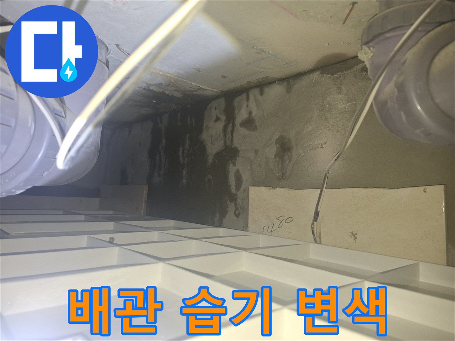 화장실 천장 내부-누수로 인해 검게 얼룩진 배관 주변 벽면