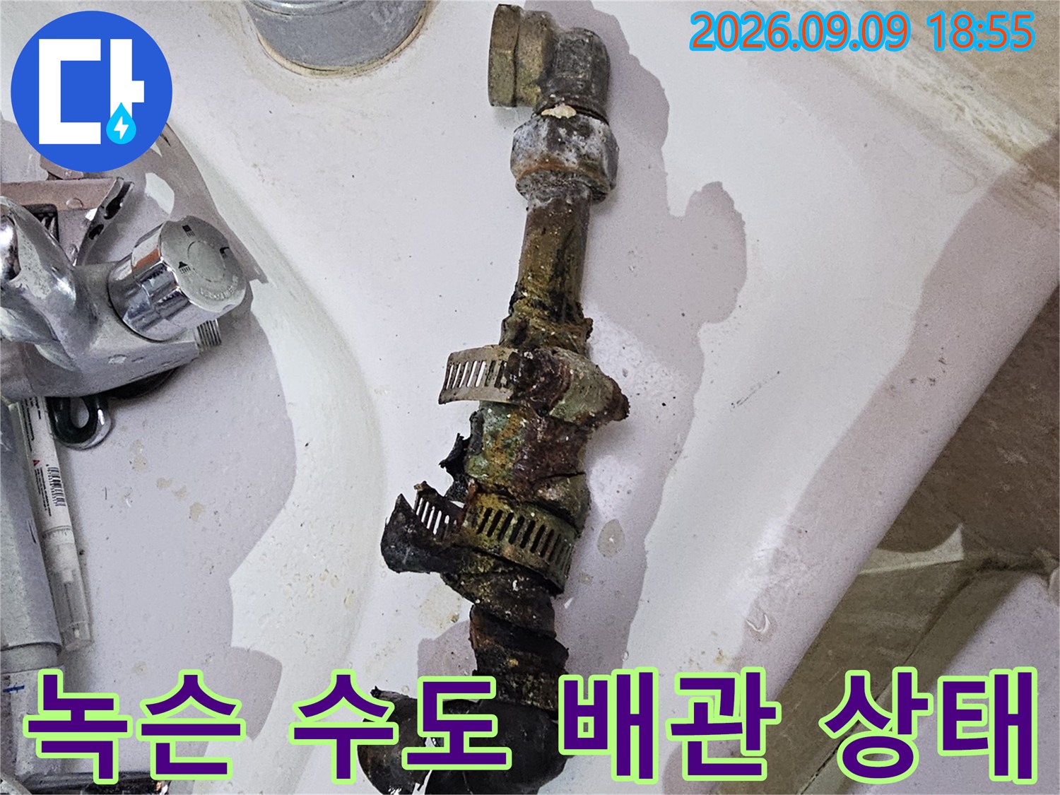 오래된 배관의 연결 부위가 녹슬고 틈이 벌어진 모습입니다.