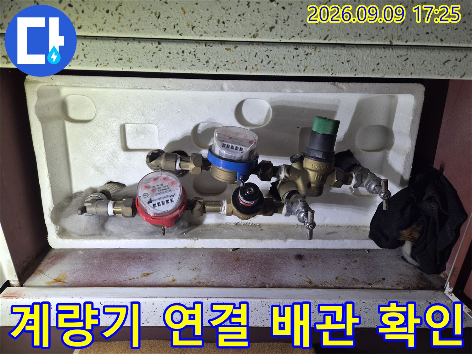 수도 계량기와 밸브 사이의 배관 연결 상태를 근접 촬영한 사진