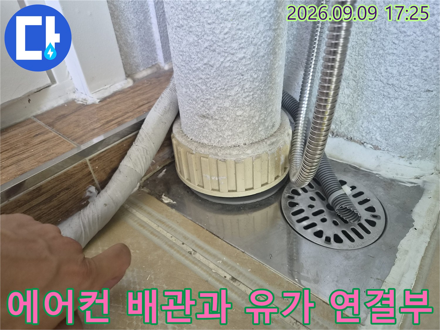 에어컨 드레인 호스와 금속 재질의 배수구 유가가 설치된 현장 모습입니다.