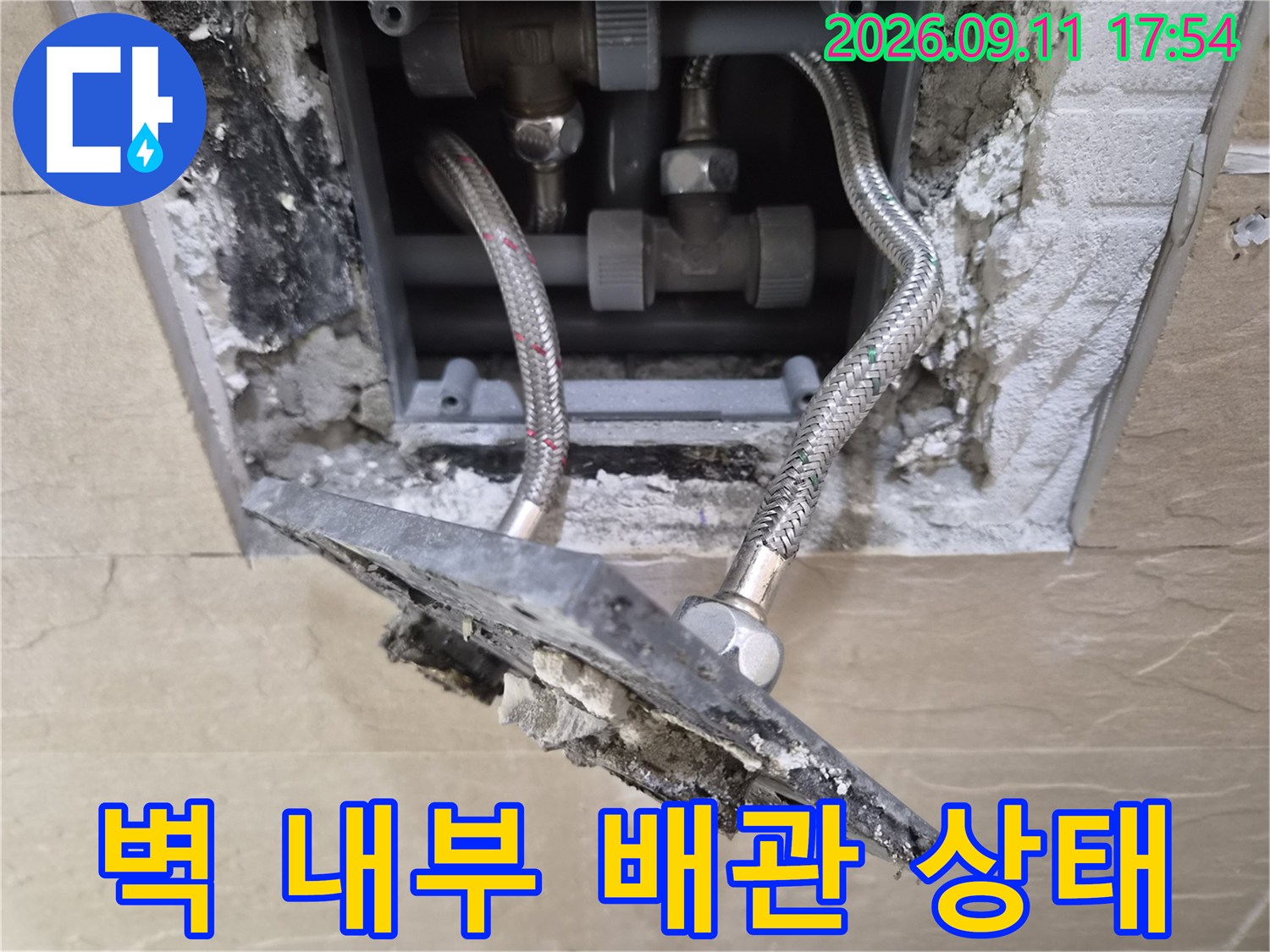 욕실 타일을 제거하여 드러난 샤워기 연결 배관 부속