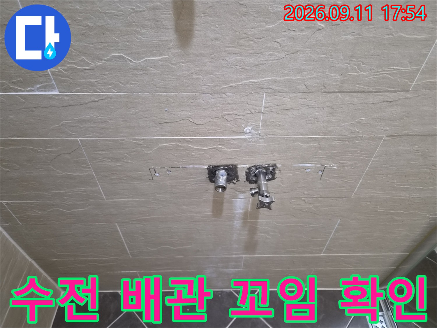 타일 사이로 보이는 꼬여 있는 샤워기 매립 배관