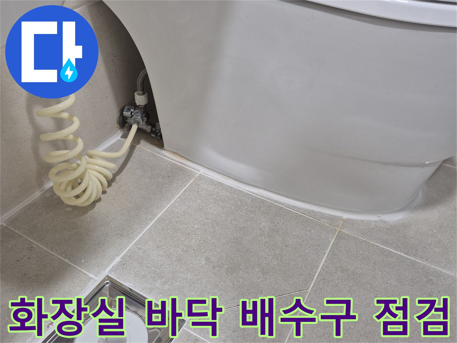 변기 옆 타일 바닥에 설치된 배수구와 연결된 공압 검사 호스