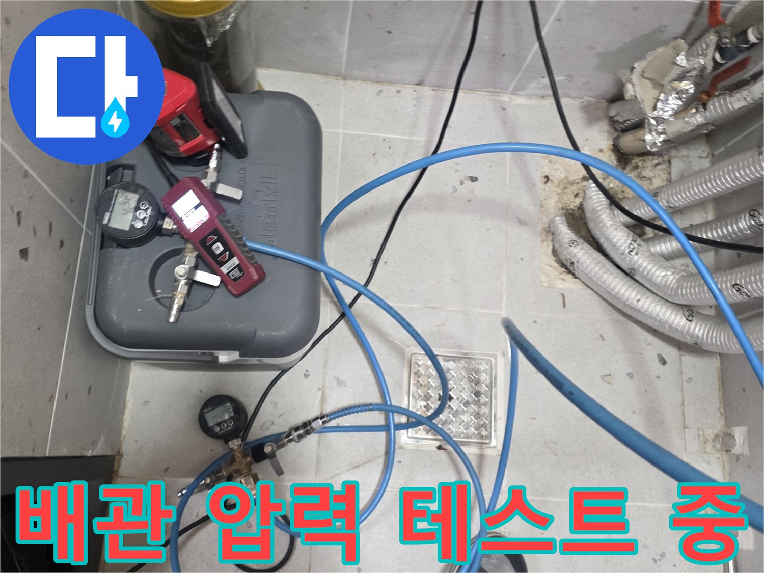 가스 탐지 장비와 파란색 호스를 연결하여 배관의 압력을 점ኩ하는 모습