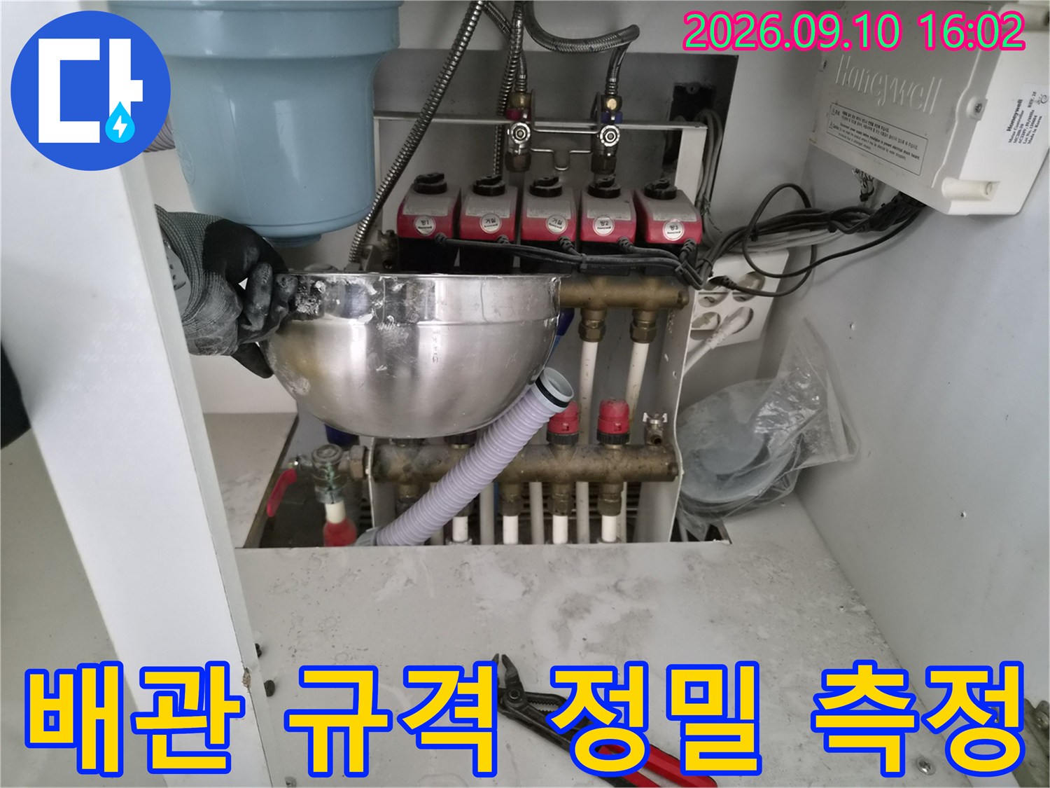 금속제 버니어캘리퍼스를 이용해 배관의 두께를 재는 작업 현장입니다.