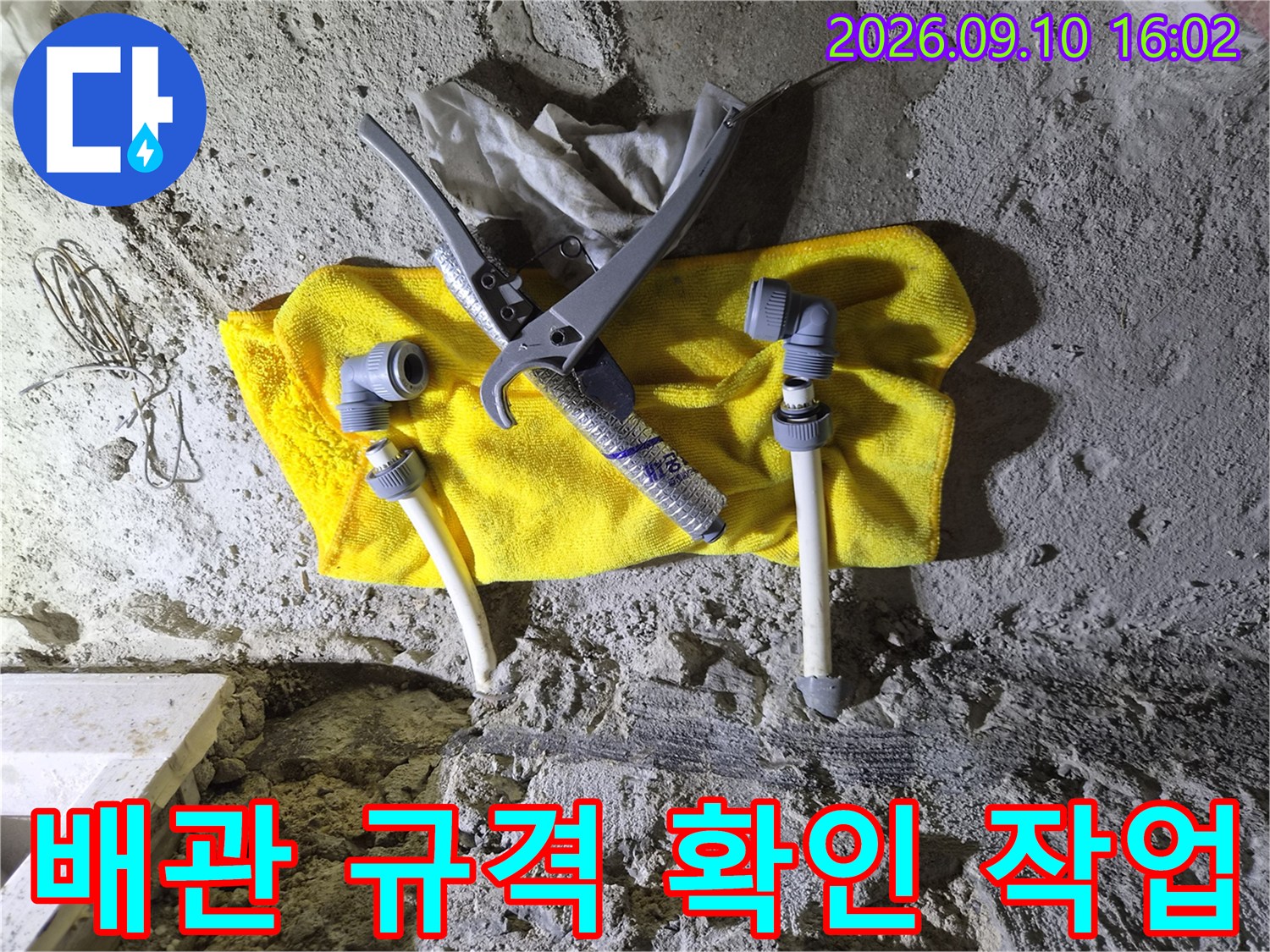 노란 수건 위에 놓인 배관 부속과 측정용 캘리퍼스