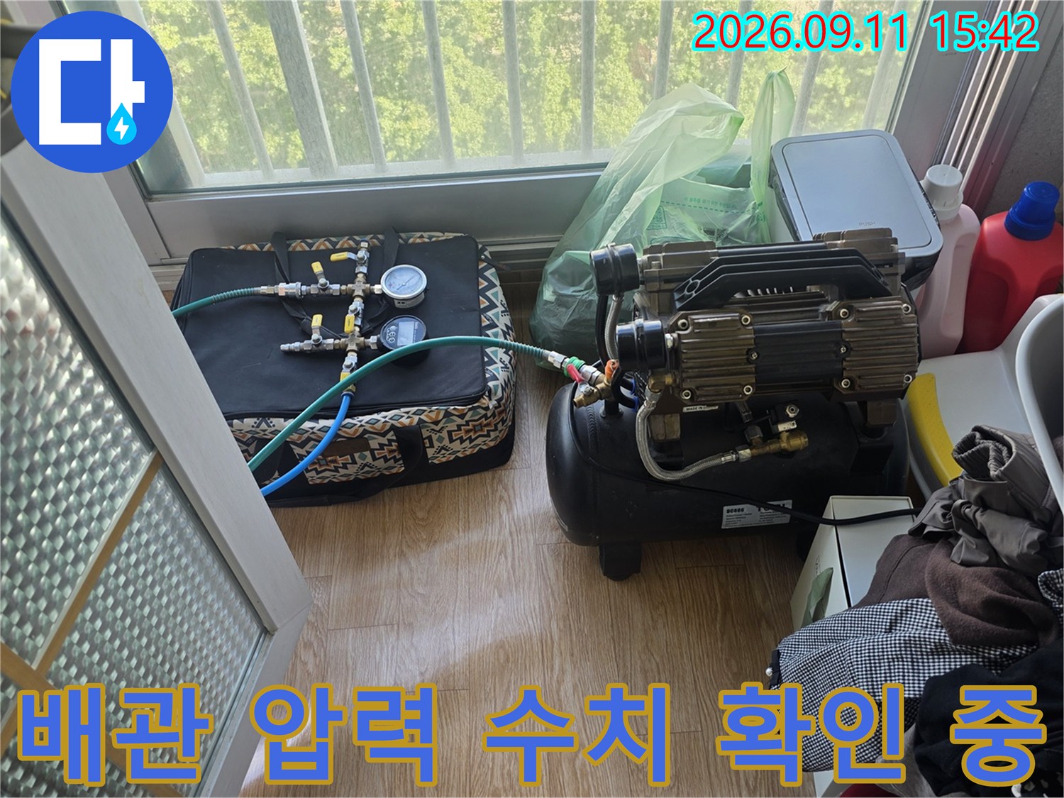 배관의 누수 여부를 판단하기 위해 설치된 압력 게이지와 호스 연결부