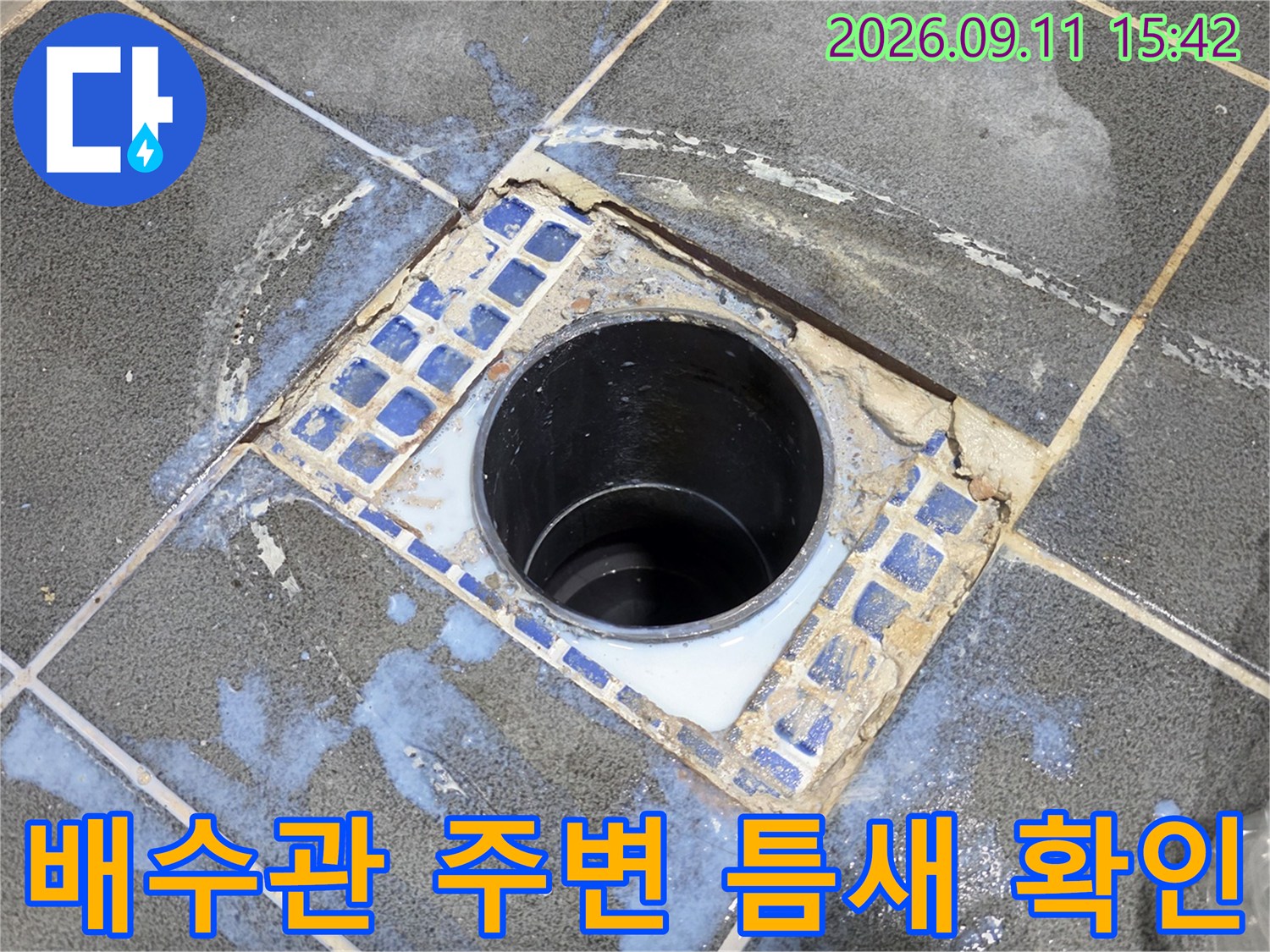 화장실 배수관 입구와 유가 사이의 벌어진 틈을 근접 촬영한 사진입니다.