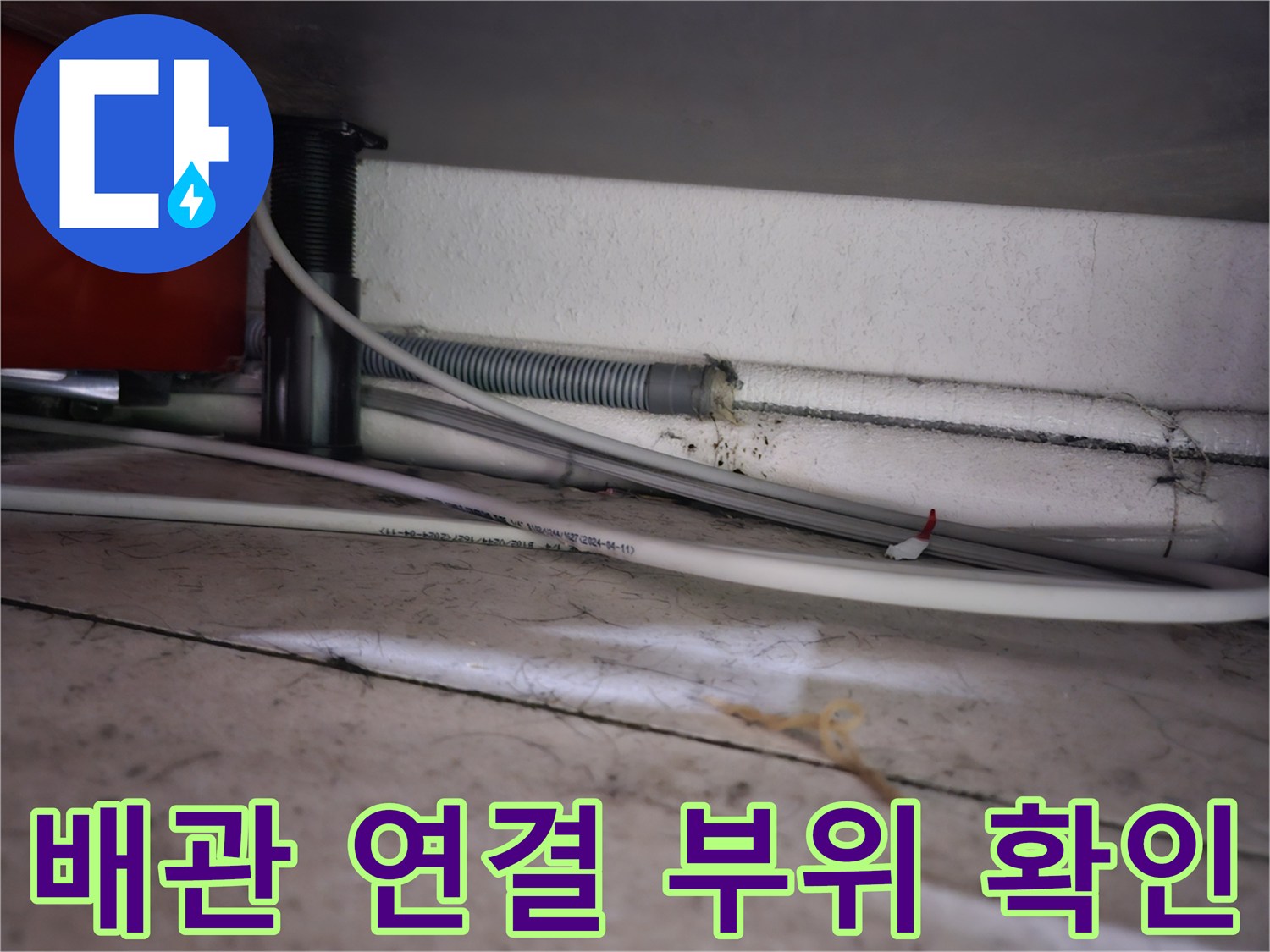 세면대 아래쪽 하얀색 관과 검은색 밸브 연결 구간의 근접 사진입니다.