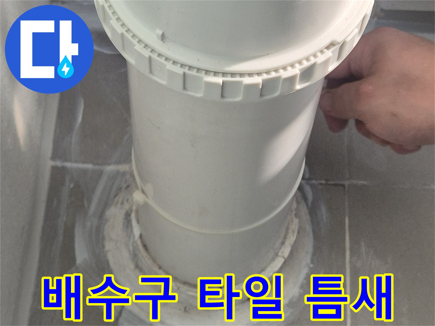 하수 배관과 벽면 타일 사이의 벌어진 공간을 근접 촬영한 사진
