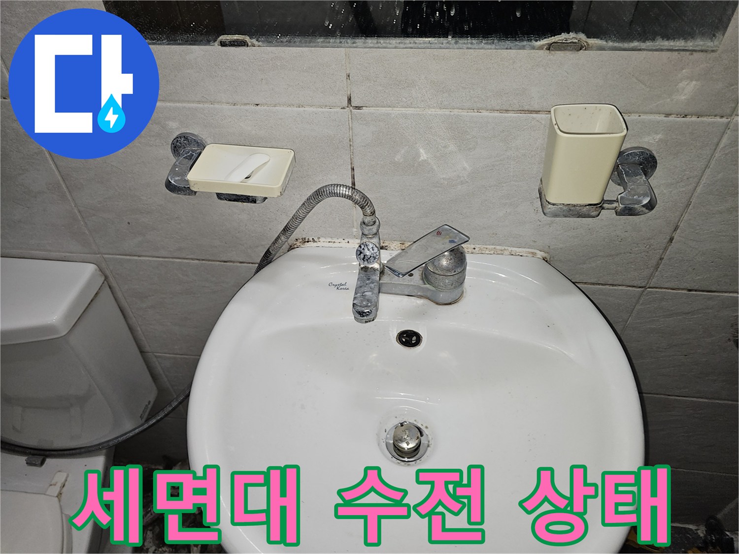 화장실 세면대와 벽면에 설치된 수도 장치 사진