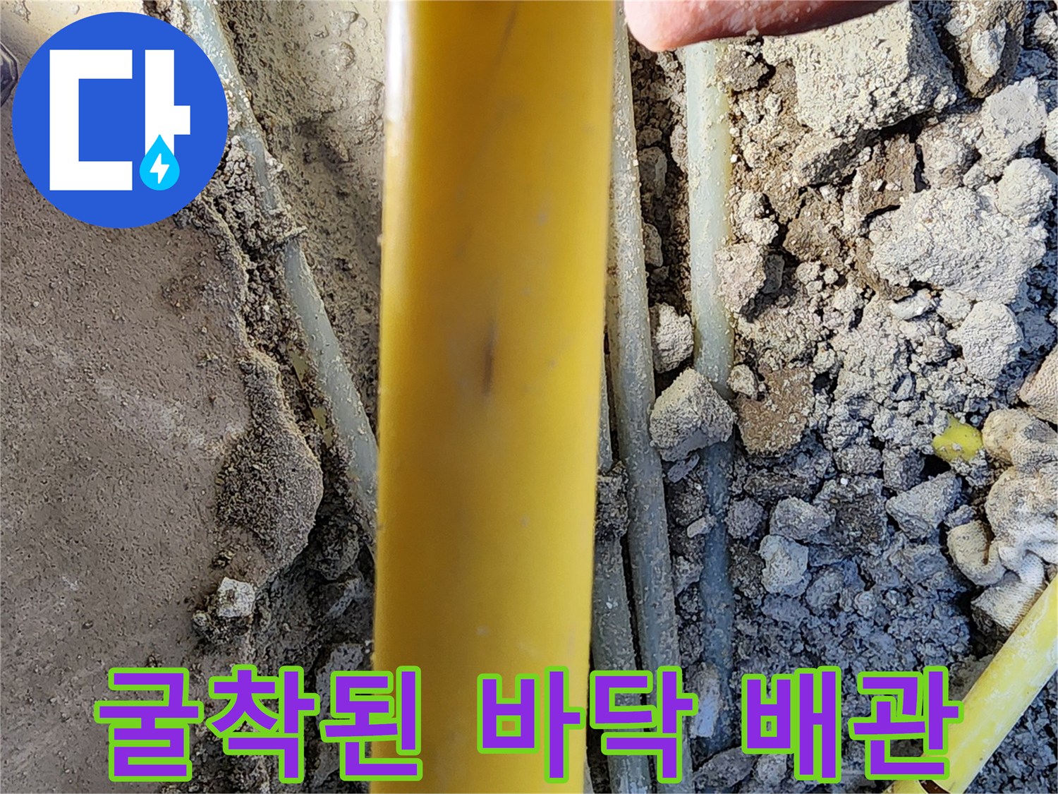 콘크리트 아래에 드러난 노란색 및 흰색 매립 배관