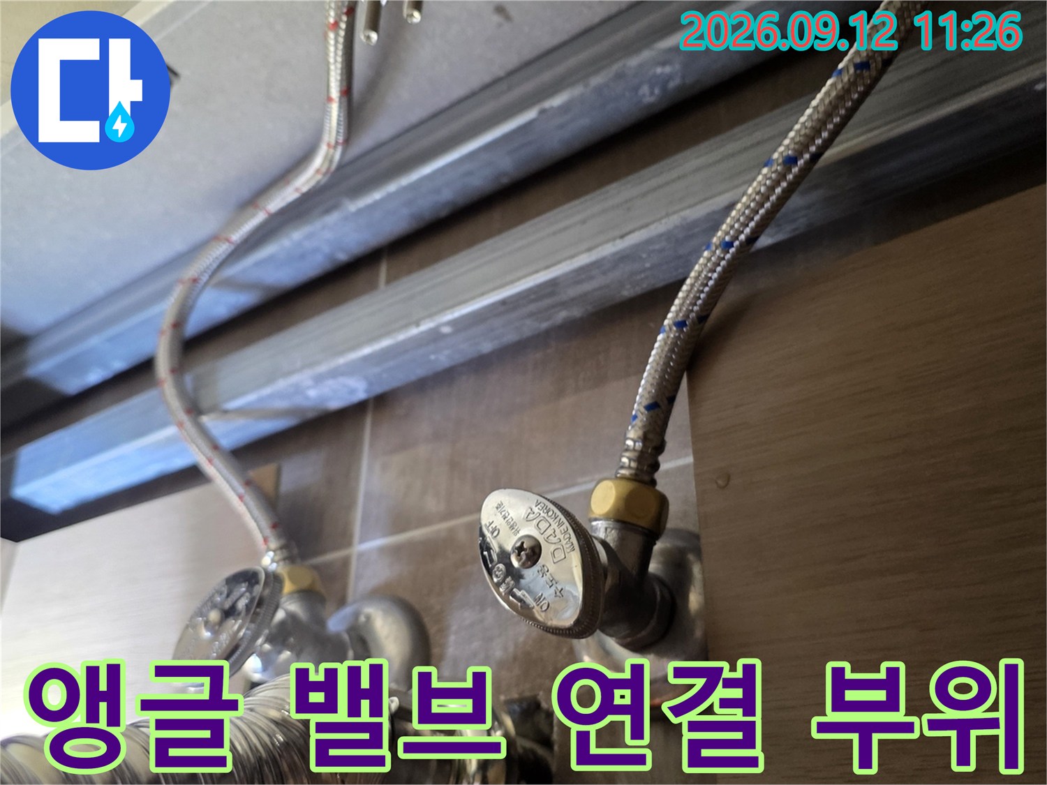 세면대 아래쪽 은색 금속 배관과 밸브의 상세 모습