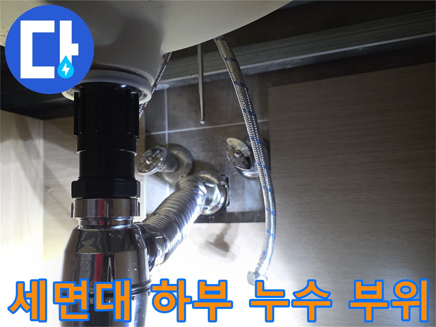 세면대 아래쪽 은색 배관 및 연결 호스의 근접 촬영