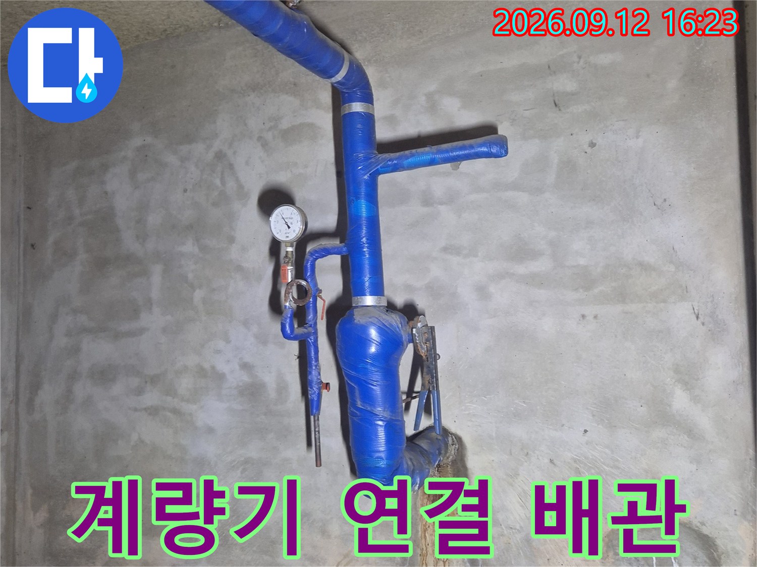 수도 계량기와 파란색 보온재로 덮인 급수 배관의 상세 모습